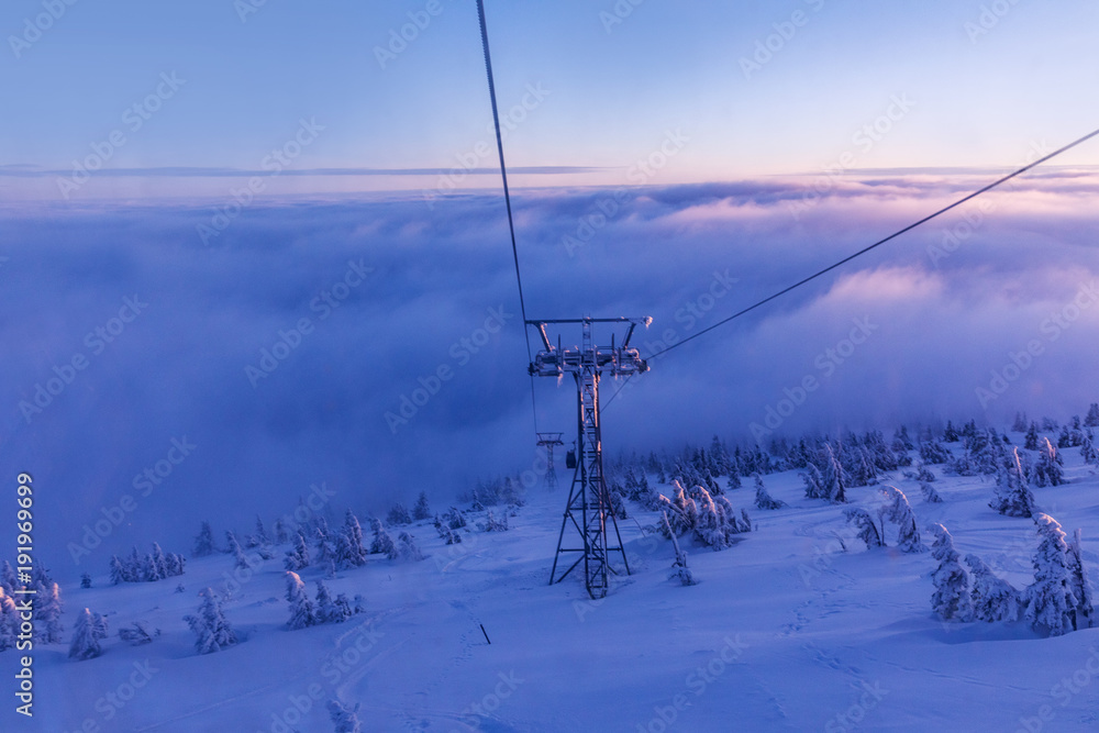 The cabin lift at Snezka, the lifts of the cable car and the winter landscape lit by the sunset in the beautiful colors of the winter. Sunset in the Giant Mountains.
