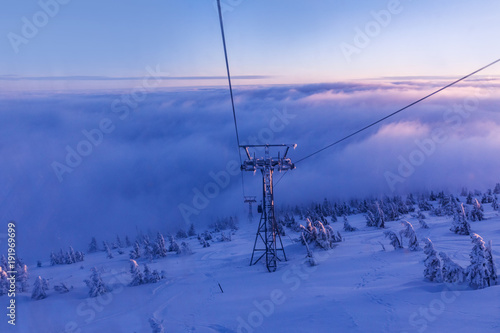 The cabin lift at Snezka, the lifts of the cable car and the winter landscape lit by the sunset in the beautiful colors of the winter. Sunset in the Giant Mountains. © murmakova