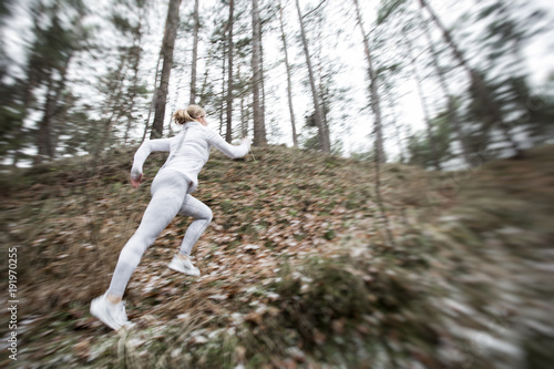 Motion blurred woman running in forest