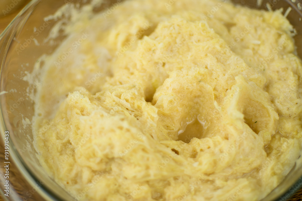 The hand is kneading grated potatoes to make dough. The hand is kneading grated potatoes to make dough.