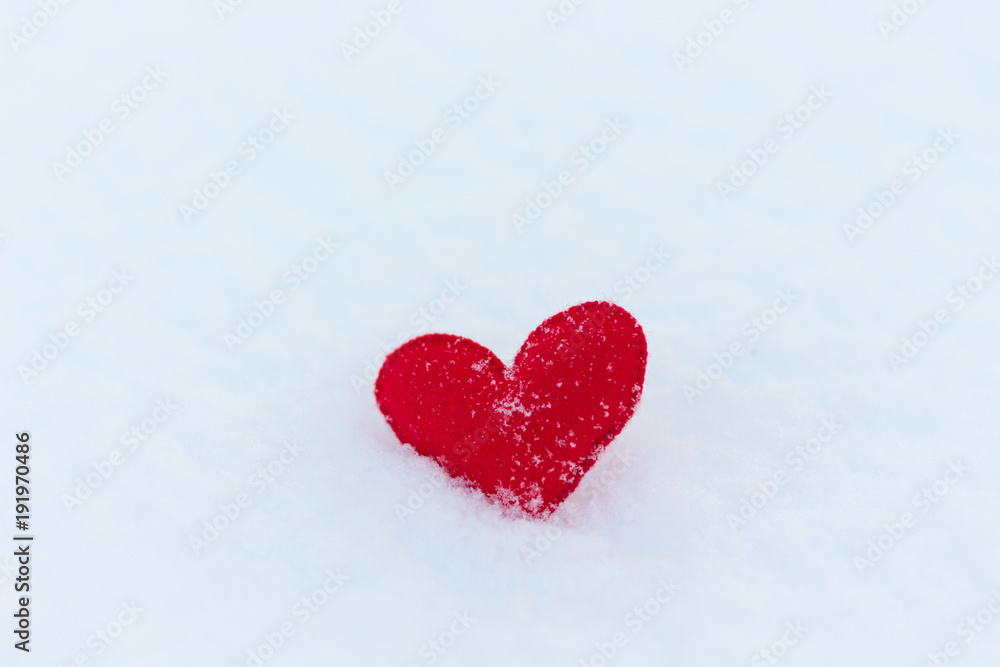 red felt heart figure on snow, winter day