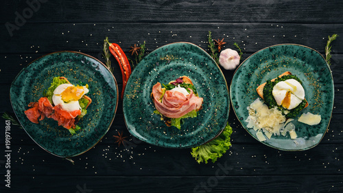 Tableau sur toile Poached egg with salmon, bacon and parmesan on a wooden background