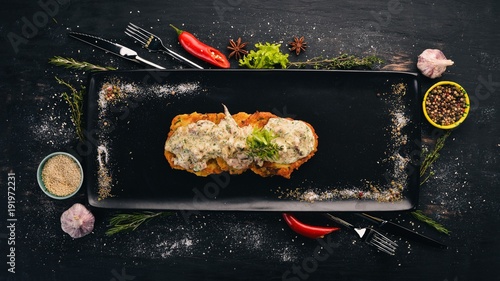 Potato pancakes with pork. Hot appetizers. Top view. On a black wooden background. Copy space.
