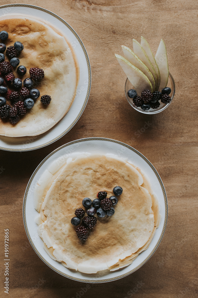 top view of delicious homemade pancakes with healthy berries on wooden table top view of delicious homemade pancakes with healthy berries on wooden table