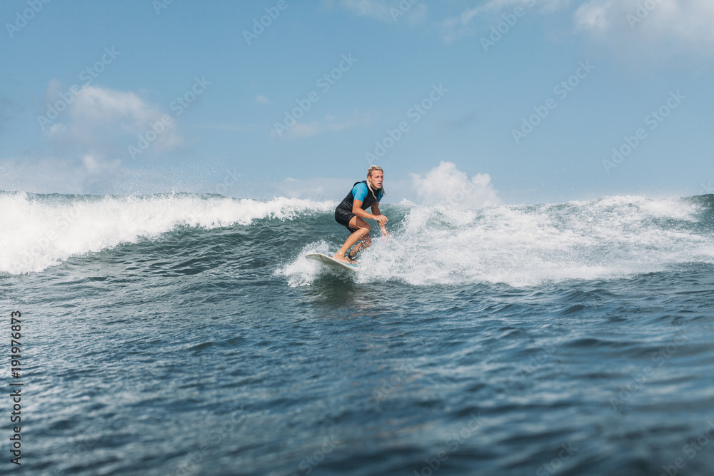 surfer riding wave on board in ocean