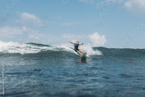 male surfer riding wave on surf board in ocean
