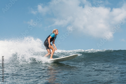 male surfer riding wave on surf board in ocean