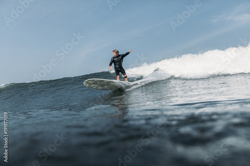 Photography man having fun and surfing wave on board in ocean