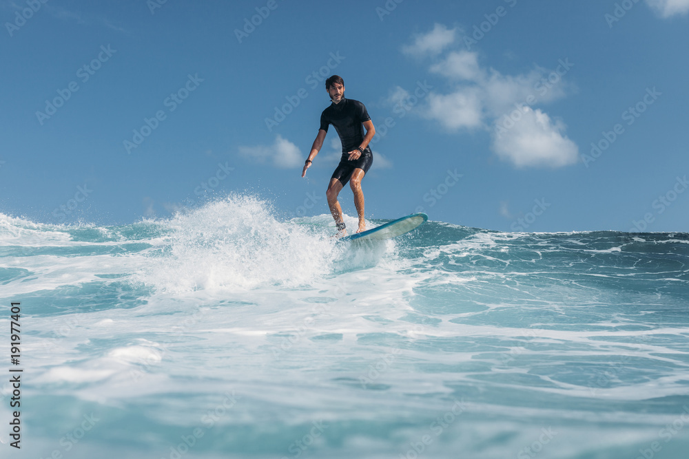 man surfing wave on surf board in ocean man surfing wave on surf board in ocean