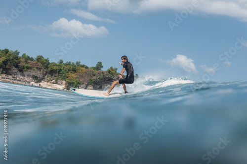 active man surfing wave on surf board in ocean
