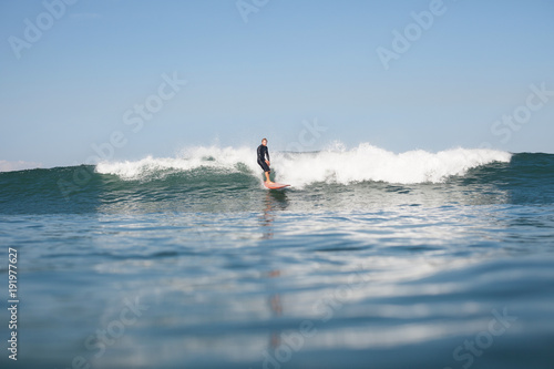active sportsman surfing wave in ocean