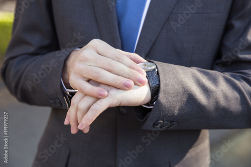 Man in business suit looking at his watch