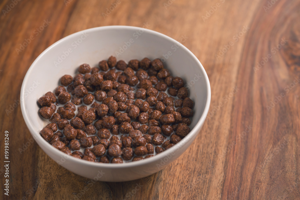 chocolate cereal breakfast in white bowl on wood table chocolate cereal breakfast in white bowl on wood table