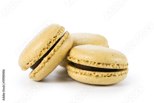 three yellow macarons with jam isolated on white