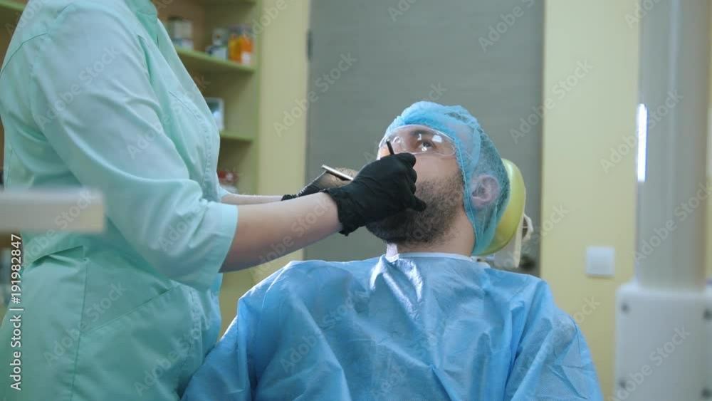 Doctor and patient in the dental office, examination man's mouth Doctor and patient in the dental office, examination man's mouth