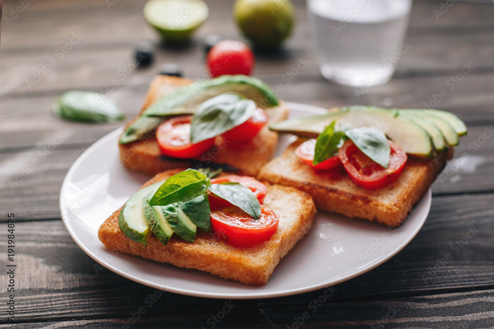 Dietary healthy food. Bread with avacado, tomatoes and Basil