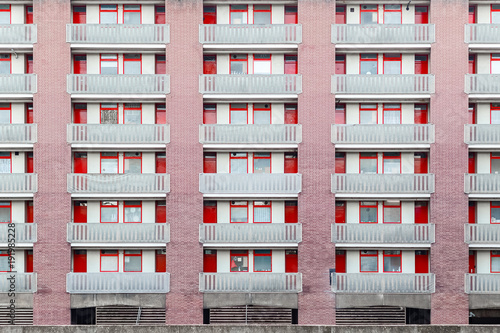 Housing block faced with panels in red colour at golden lane estate in London