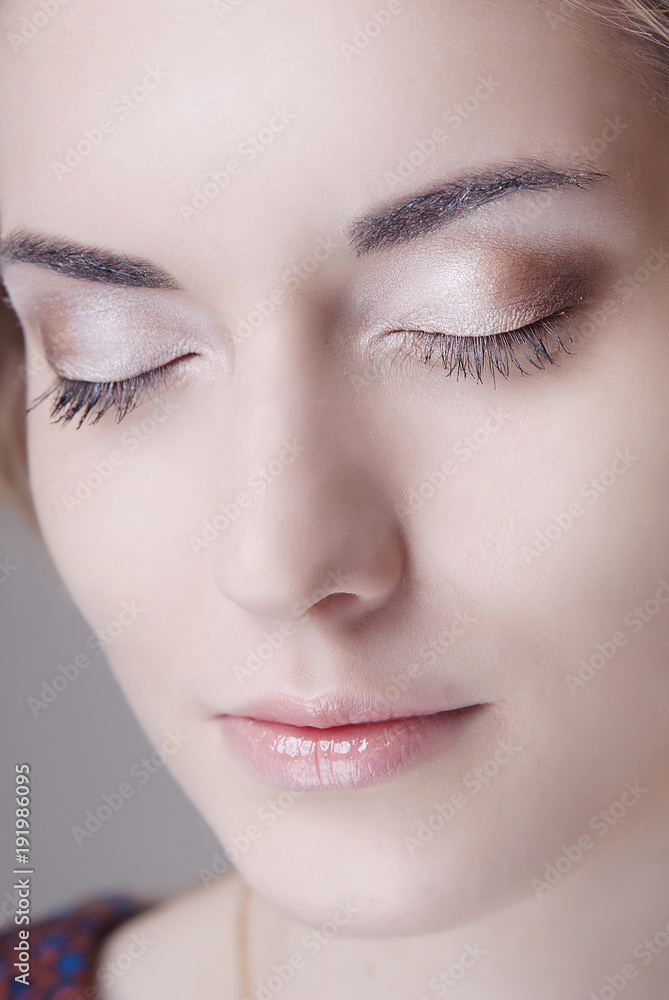 The girl's face with professional makeup on the eyes closed and clean skin close-up