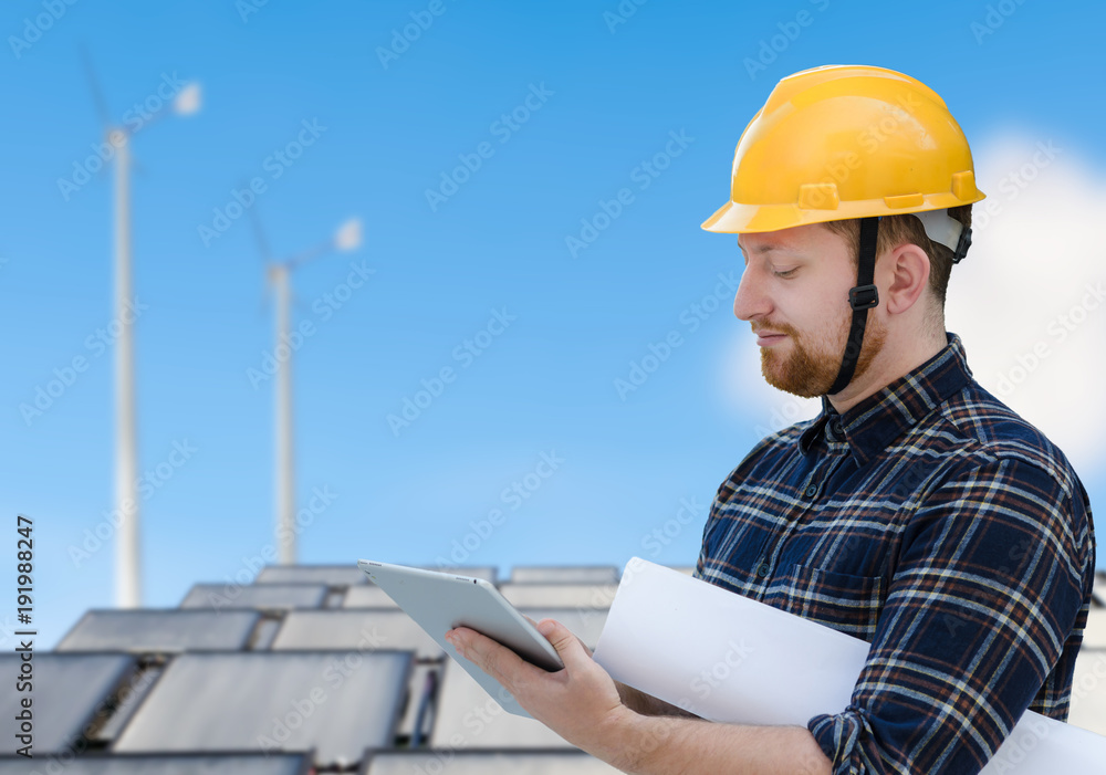 Male engineer at solar cell site with a tablet computer