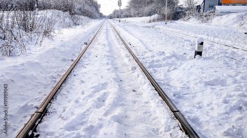 The path between the sleepers in with a bliss. Sleepers from the train, electric train in city in the winter. They are covered with snow from a storm. The road going into the distance.