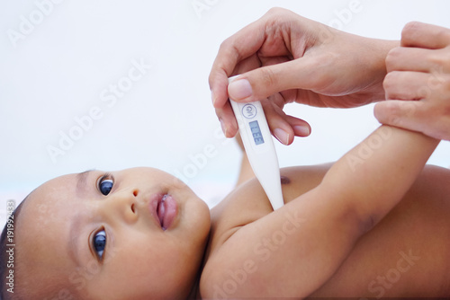 Mother Measures The Temperature Of Her Baby Using Digital Thermometer 