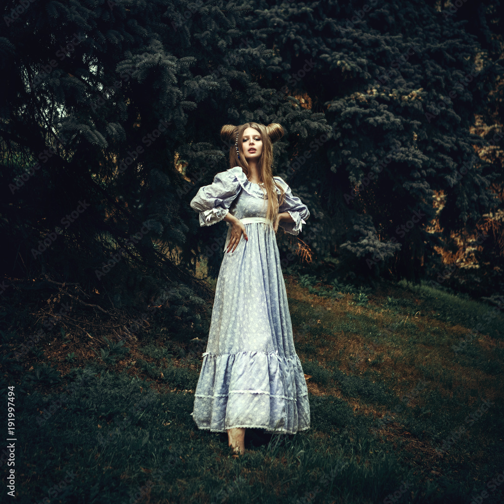 Fototapeta premium Beautiful model is posing in a forest with horns made from hair