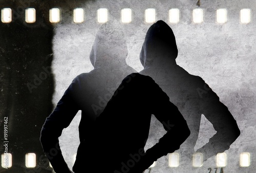 Vintage black and white doubled silhouette of young man with hooded sweatshirt and film strip frame.