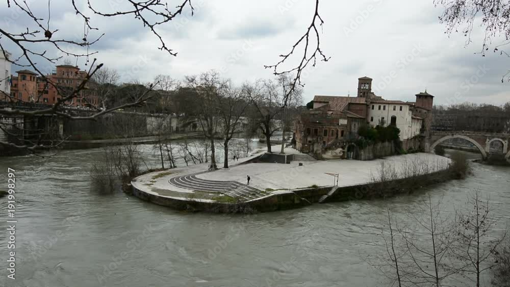 Tiberina Island on the Tiber River, Rome Italy, with dark and cloudy sky Tiberina Island on the Tiber River, Rome Italy, with dark and cloudy sky