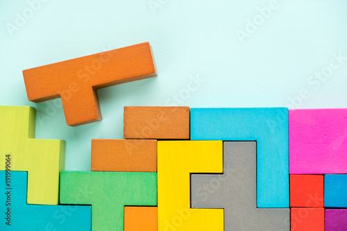 Different colorful shapes wooden blocks on blue background, flat lay. Geometric shapes in different colors, top view. Concept of creative, logical thinking or problem solving. Copy space. photo