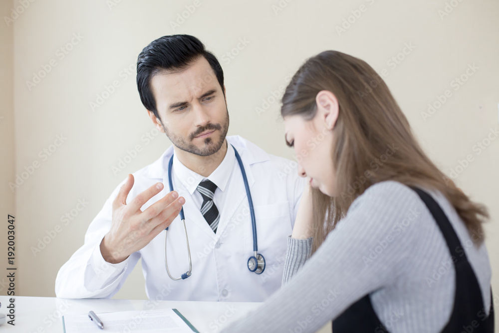 Attractive Doctor working at hospital. Doctor try to treat woman for any problem. He holding her hand. Attractive Doctor working at hospital. Doctor try to treat woman for any problem. He holding her hand.