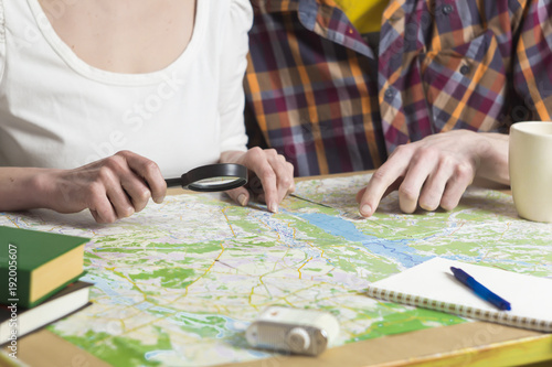 Planning to travel. A man and a woman choose a place on the map for recreation.
