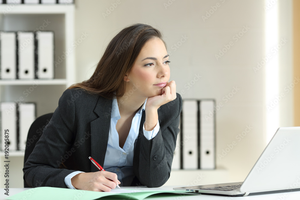 Businesswoman thinking looking away at office Businesswoman thinking looking away at office