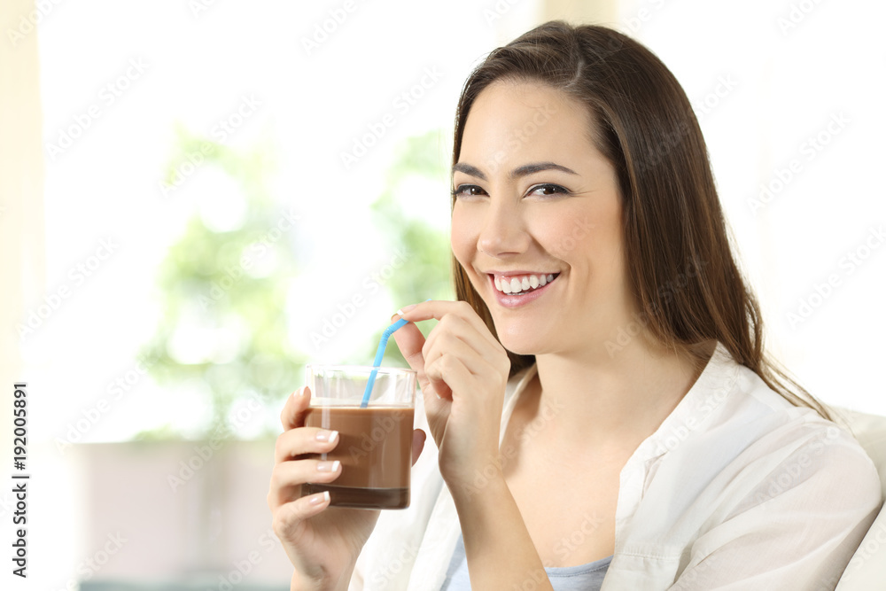 Woman drinking cocoa shake looking at camera Woman drinking cocoa shake looking at camera