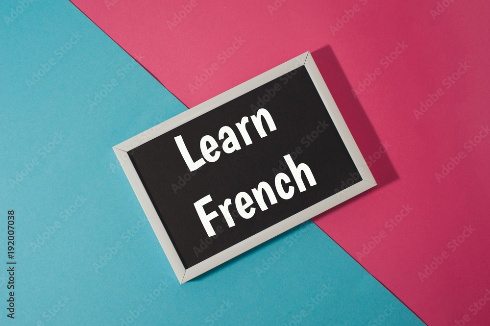 Learn French - text on chalkboard on blue and pink bright background. Learn French - text on chalkboard on blue and pink bright background.