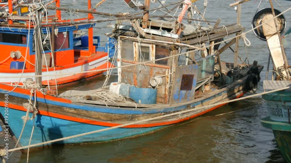 PATTAYA, THAILAND - DECEMBER 25, 2017: A large number of wooden fishing boats are moored on quay PATTAYA, THAILAND - DECEMBER 25, 2017: A large number of wooden fishing boats are moored on quay