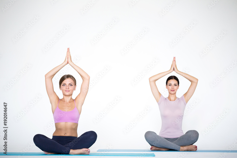 Group of women meditating in lotus yoga pose.