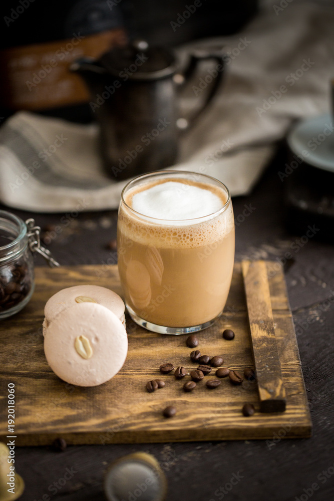 Φωτογραφία The perfect tasty breakfast!) The cup of latte or cappuccino coffee with milk and peanut, vanilla macarons on a wooden cutting board