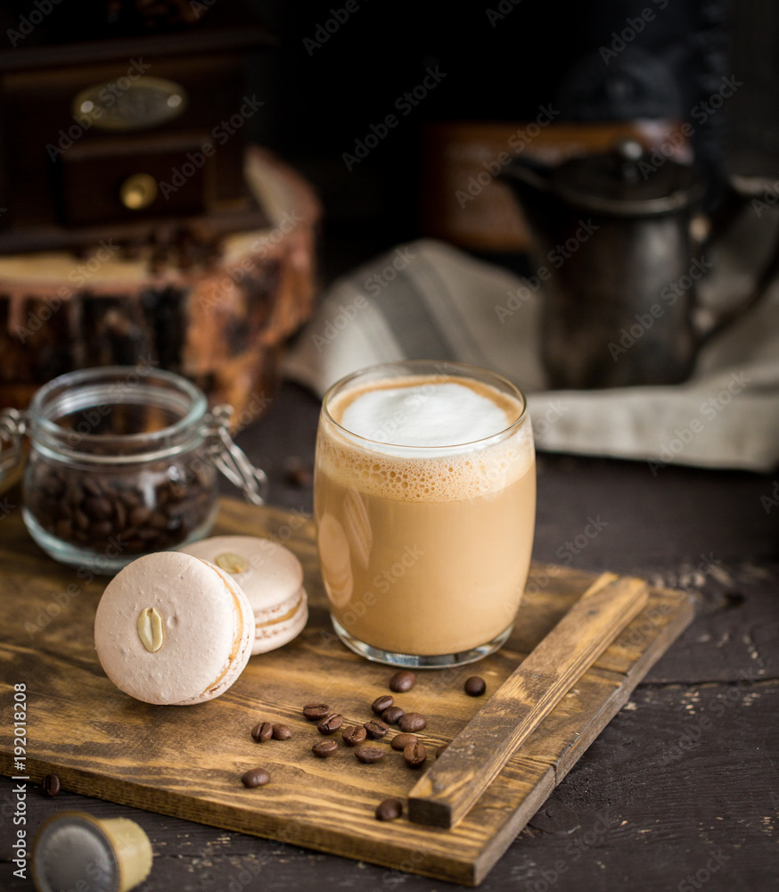 Φωτογραφία The perfect tasty breakfast!) The cup of latte or cappuccino coffee with milk and peanut, vanilla macarons on a wooden cutting board