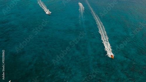 Aerial view of speed boat in sea, Boracay. Speed boat at sea, view from above. Speedboat floating in a turquoise blue sea water. Motorboat crossing ocean. Tropical landscape. Philippines © Alex Traveler
