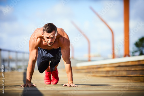Athletic man doing push-ups during an outdoors workout