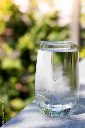 one water glass with blur green background
