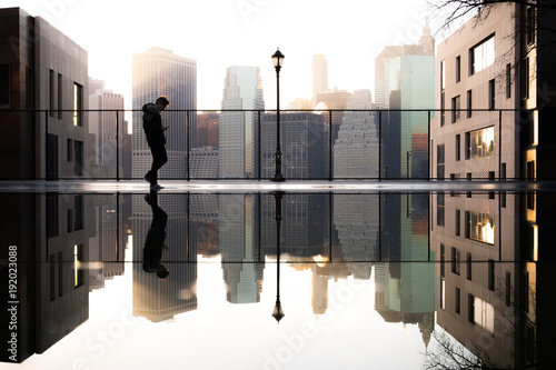 Reflection of man and cityscape in water