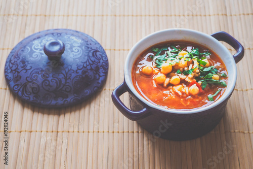 Thick Moroccan Harira soup in a bowl close-up on the table.
 photo