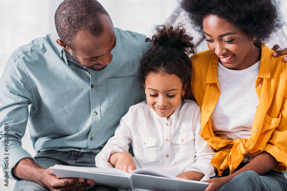 african american daughter reading for happy parents at home african american daughter reading for happy parents at home