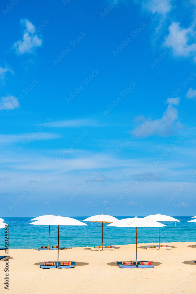 Idollic beach relaxing concept with white parasols on sand