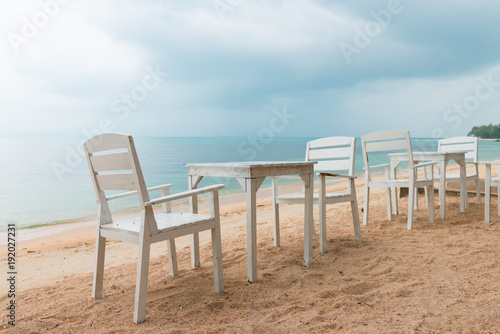 Romantic cafe with white tables and chairs on the sea shore