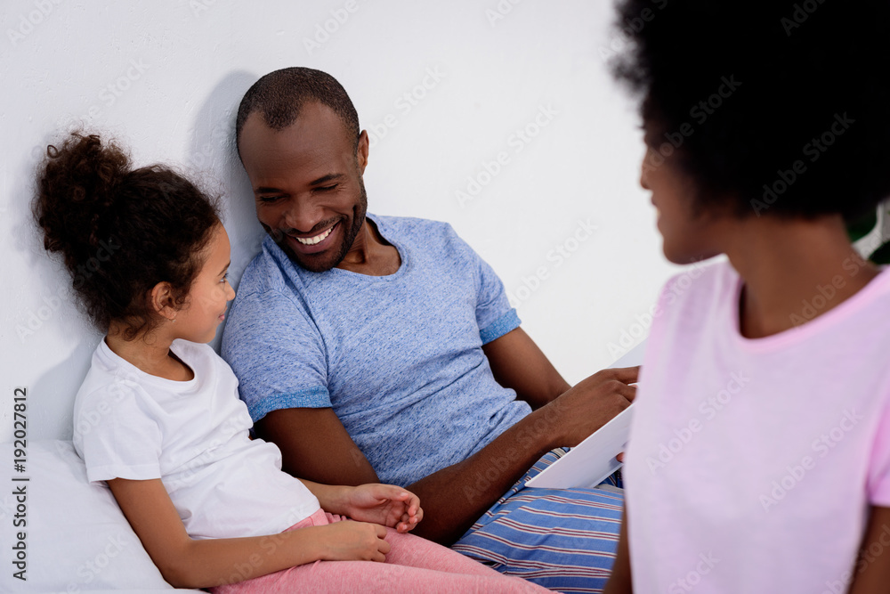 smiling african american parents and daughter looking at each other at home smiling african american parents and daughter looking at each other at home