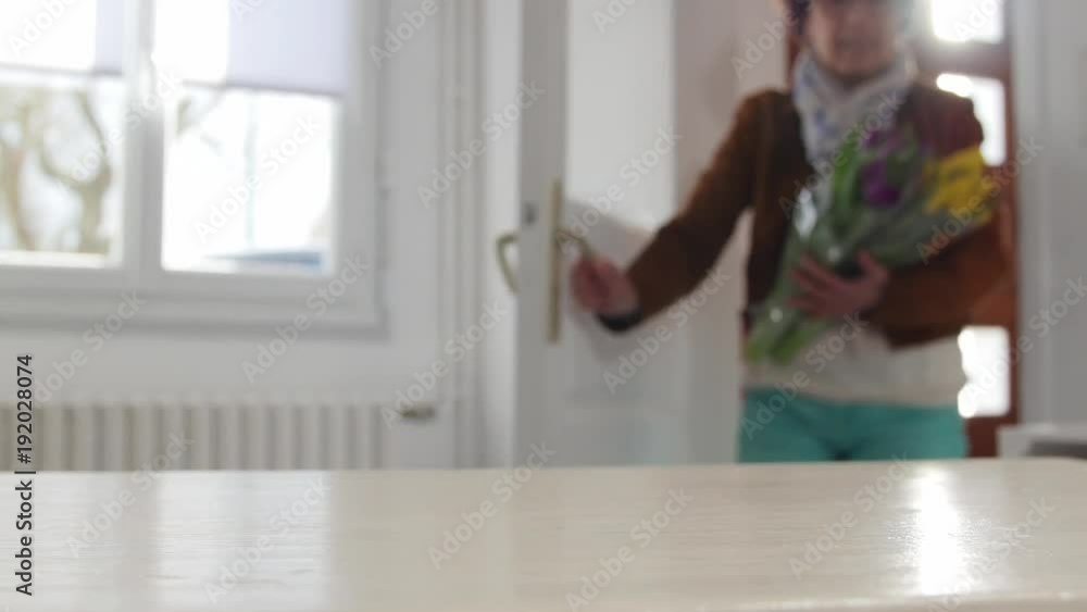 woman putting a bouquet of tulips on the table woman putting a bouquet of tulips on the table