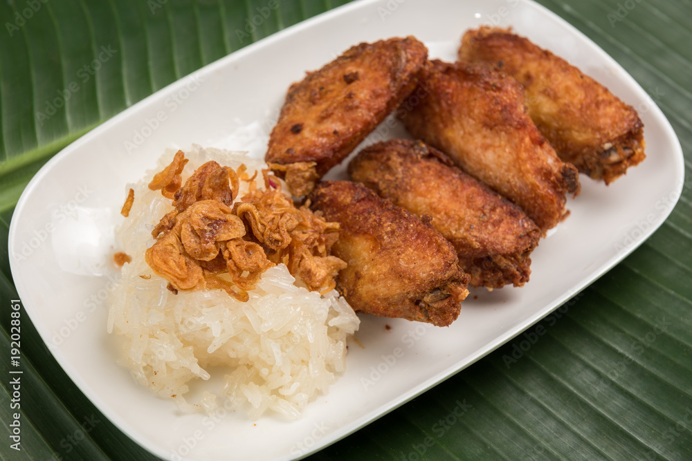 Sticky Rice and Fried chicken in plate on banana leaf Sticky Rice and Fried chicken in plate on banana leaf