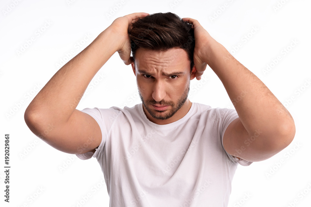 Handose bearded manwith a sexy look is holding his hair, Beautiful guy is making a hair do. Cool boy with a confident look has a hair style Handose bearded manwith a sexy look is holding his hair, Beautiful guy is making a hair do. Cool boy with a confident look has a hair style